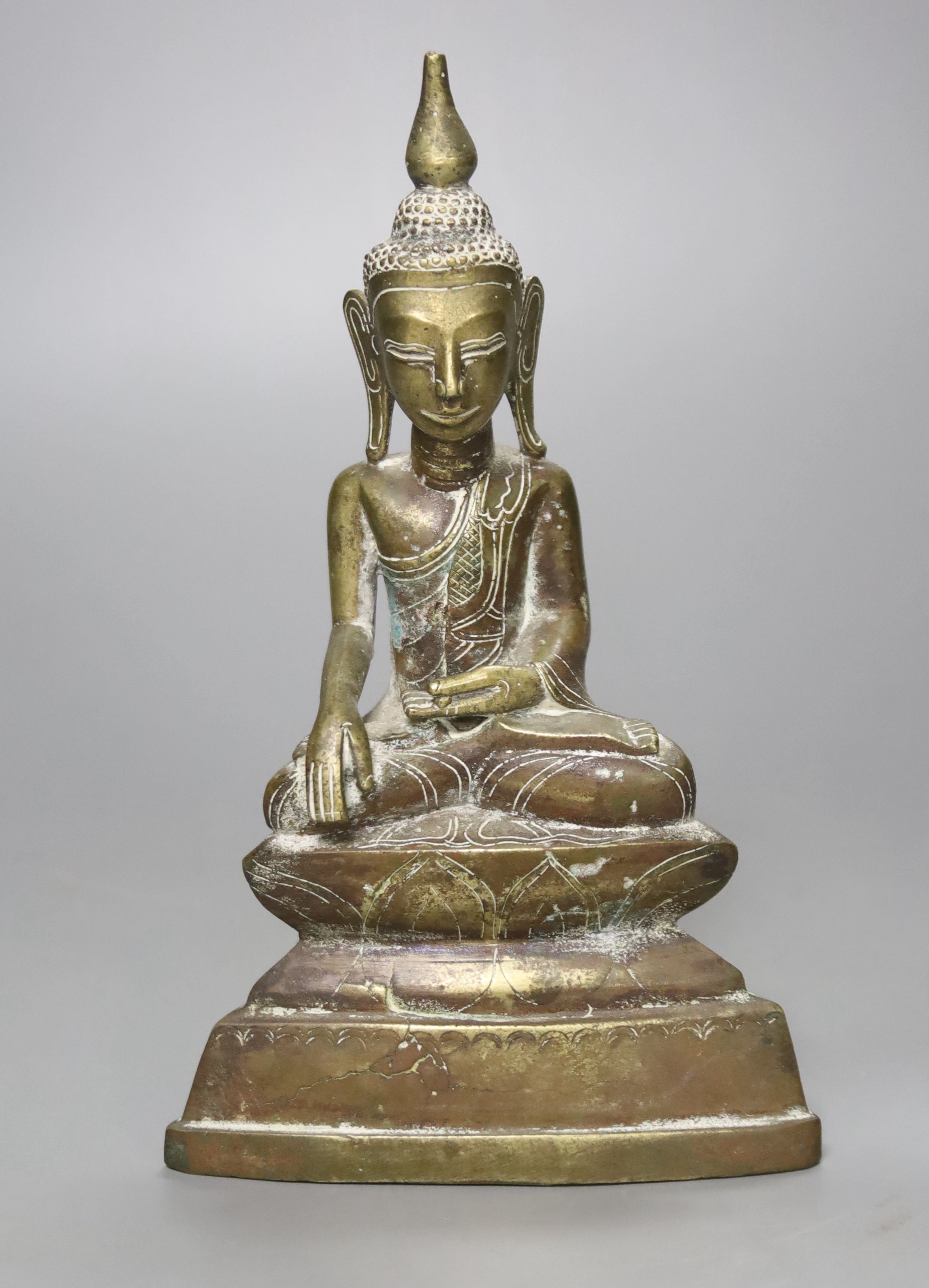 A small 19th century or later Tibetan lacquered cast brass figure of a seated Buddha, (filled), 18cm high